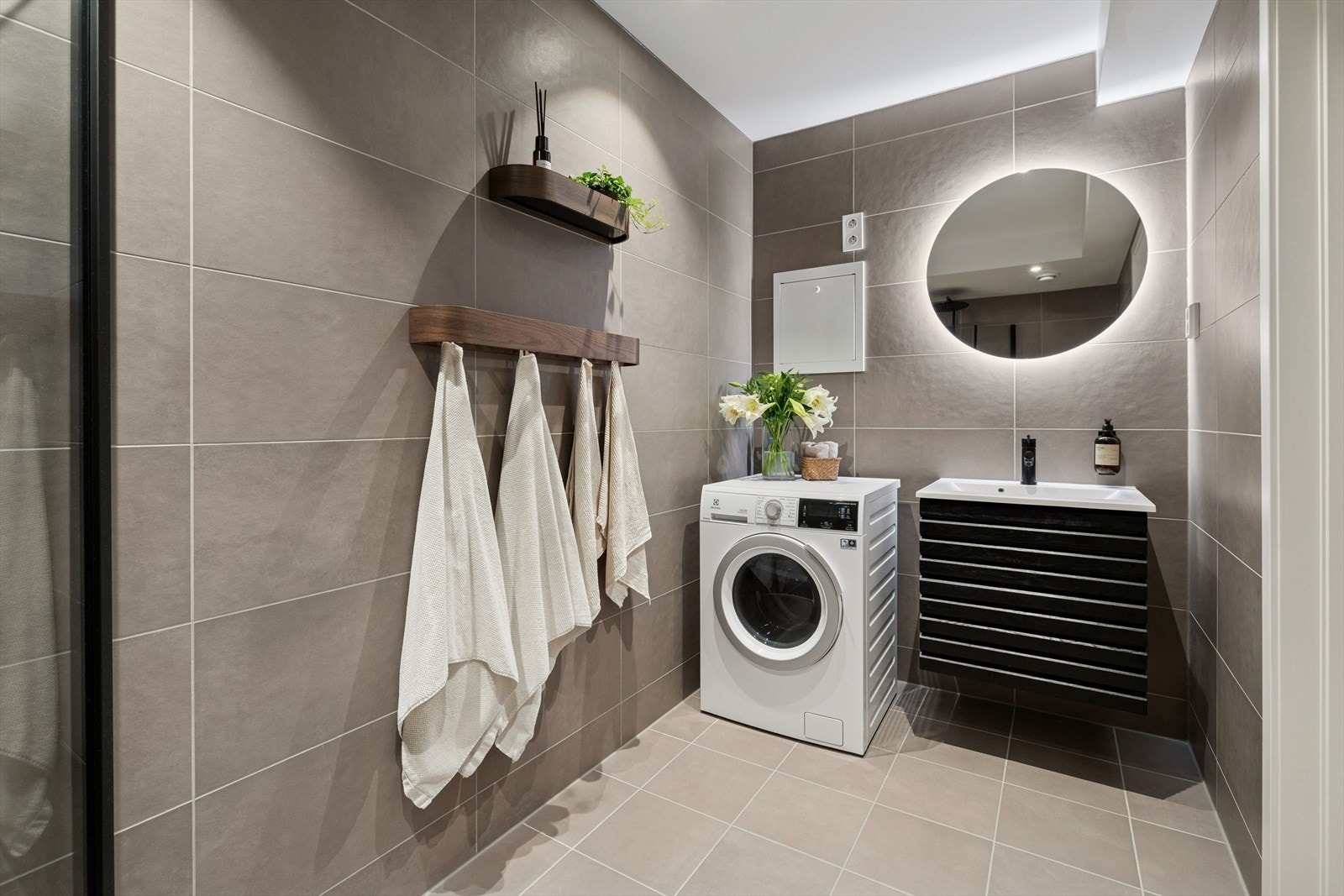 Delikat flislagt baderom med behagelig gulvvarme og opplegg for vaskemaskin. Galleribilde