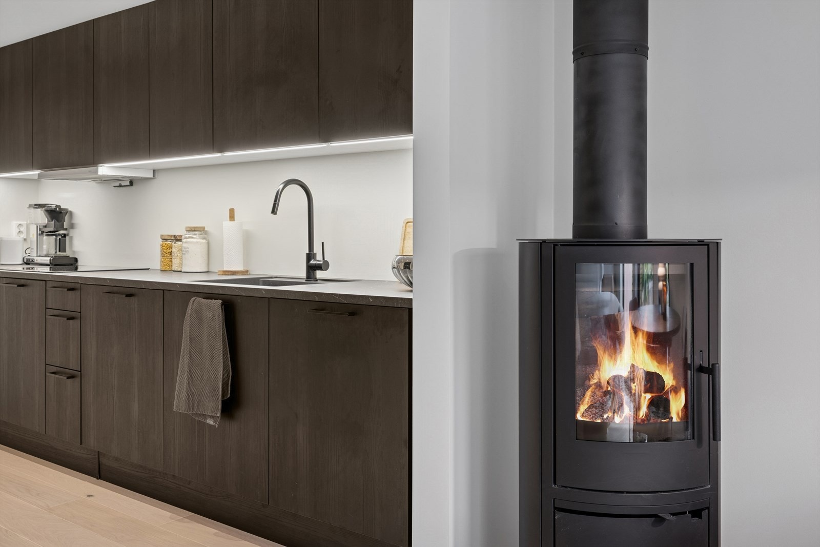 Kjøkkenet er utstyrt med nedfelt oppvaskkum i svart kompositt, ett-greps vannkran og lys montert under overskap. Galleribilde