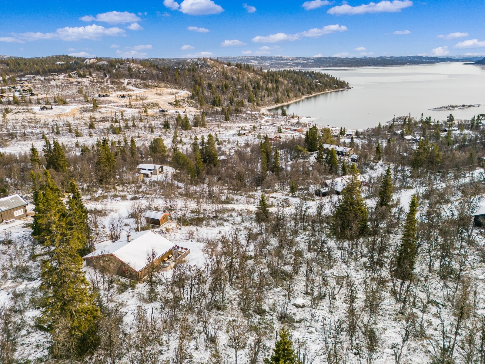 Fra hytta og terrassen er det nydelig utsikt over innsjøen Rødungen, omkranset av skog og fjellområder. Galleribilde