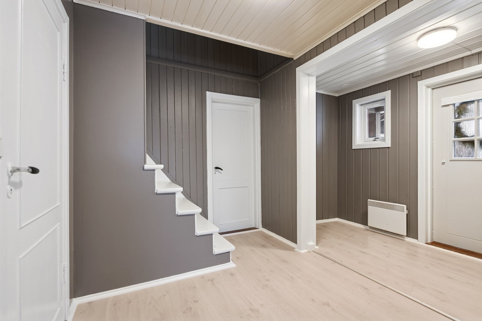 Lys og romslig entré med plass til å sette sko og henge yttertøyet. Galleribilde