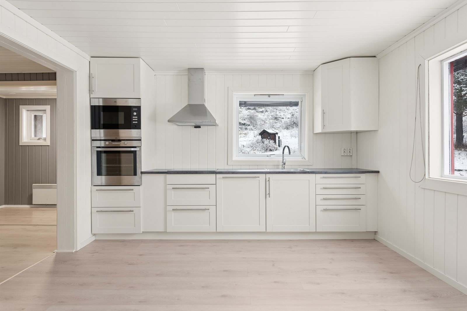 Romslig kjøkken med rom for egen spiseplass ved kjøkkenvinduet. Galleribilde