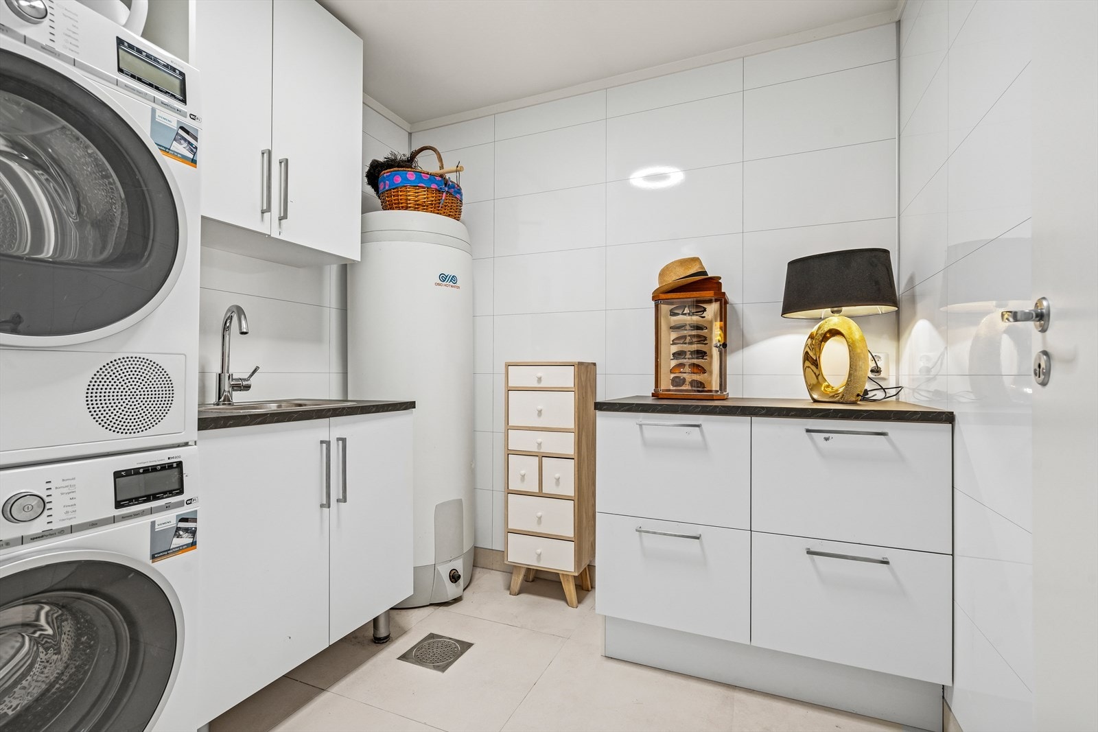 Vaskerommet fremgår på tegninger som bod og er noe utvidet (ikke søkt/byggemeldt) - Det er flislagt gulv og baderomsplater i flisimitasjon på veggene - Her finner du innredning med nedfelt servant, VVB og opplegg for vaskemaskin/tørketrommel Galleribilde