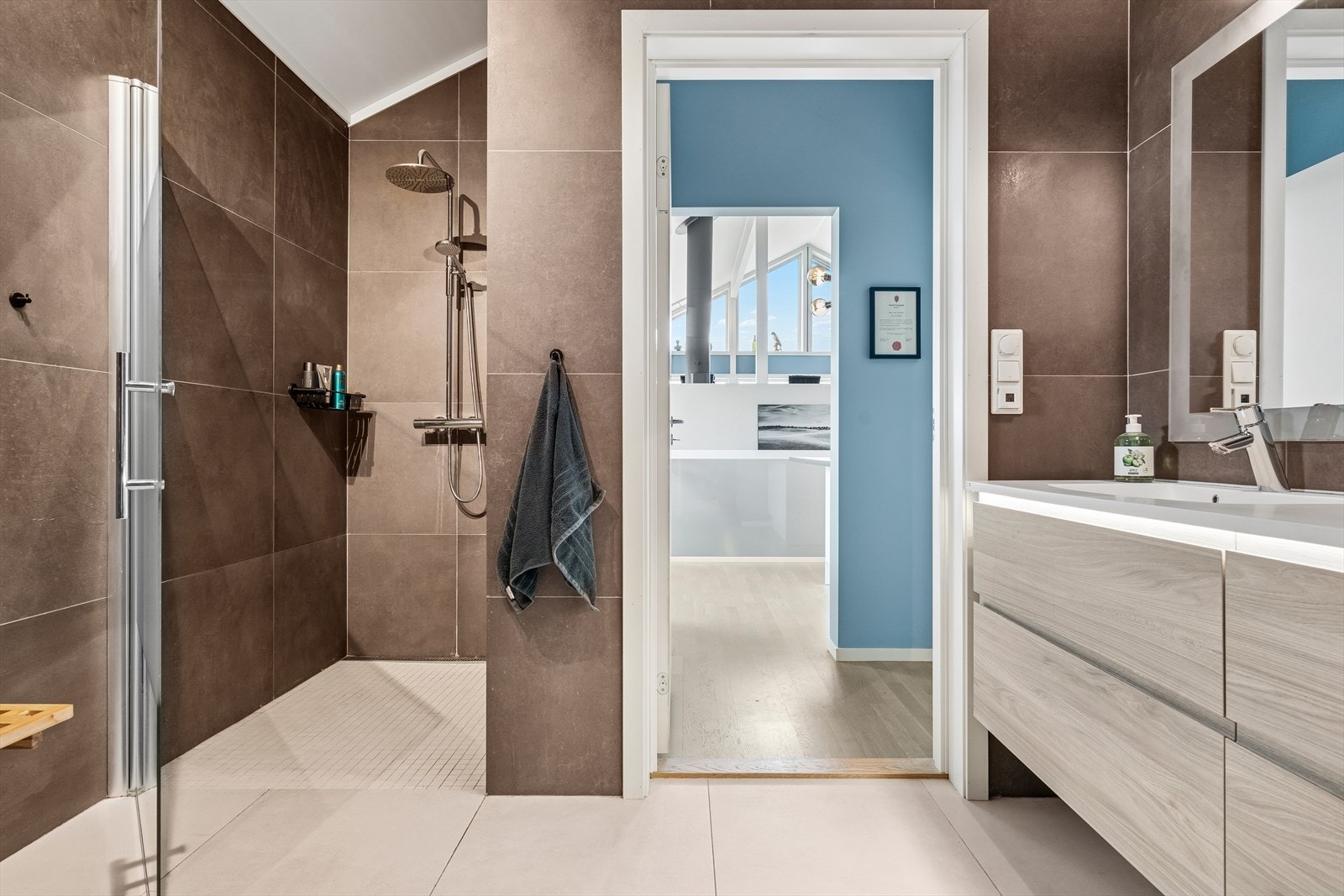 Badet er utført med moderne store fliser på både gulv og vegger Galleribilde