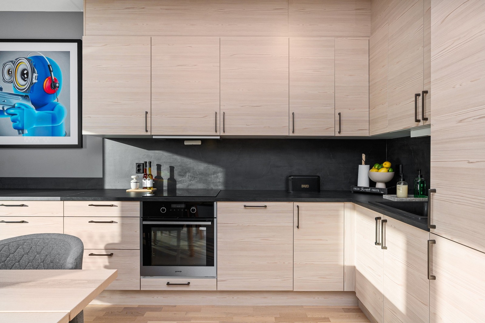 Moderne og lyst kjøkken med integrerte hvitevarer som stekeovn, platetopp, oppvaskmaskin og kjøle- og fryseskap Galleribilde