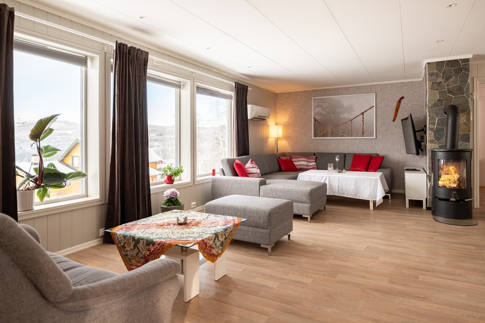 Lys og fin stue med god plass til møblering i flere soner. Også her kan man nyte den fantastiske utsikten via store vindusflater Galleribilde