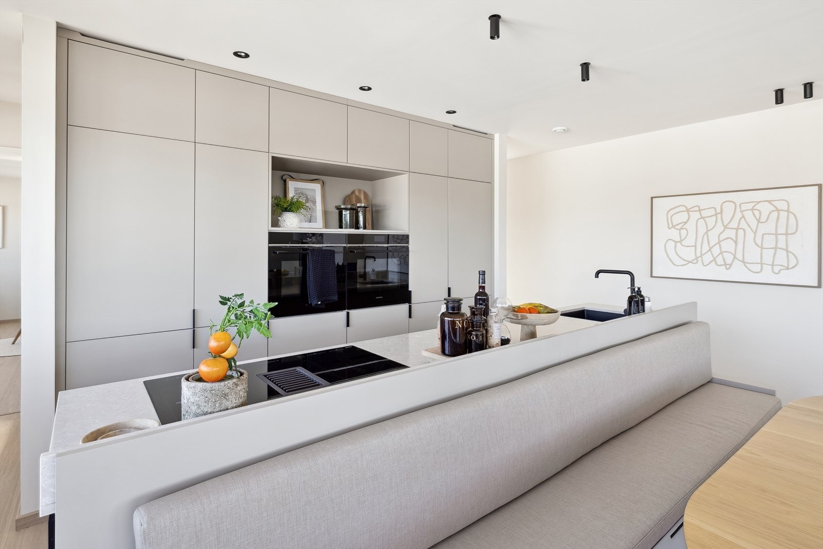 Kjøkkeninnredningen er spesial tilpasset av kjøkkenleverandør K-Design Kraus. Kjøkkenet har en åpen løsning med kjøkkenøy med plassbygget spisestuesofa Galleribilde