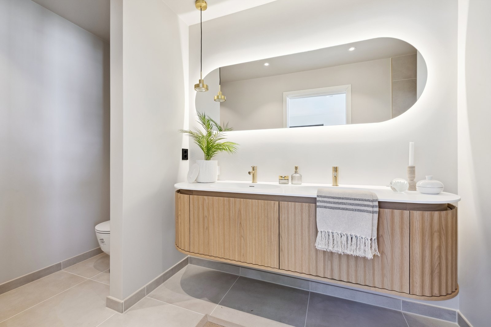 Stor og delikat baderom med med nisje for vegghengt toalett og dusj Galleribilde