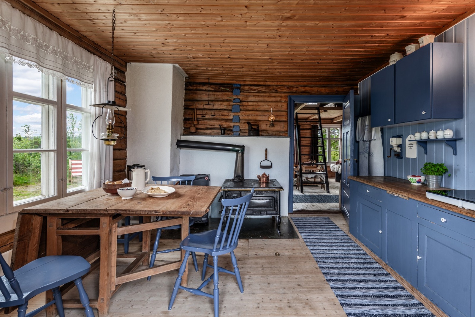 Sjarmerende kjøkken med heltre fronter malt i en nydelig blåfarge, samt heltre benkeplate. Kjøkkenet er utstyrt med en frittstående 2x2 induksjonstopp samt en vedfyrt komfyr. Galleribilde