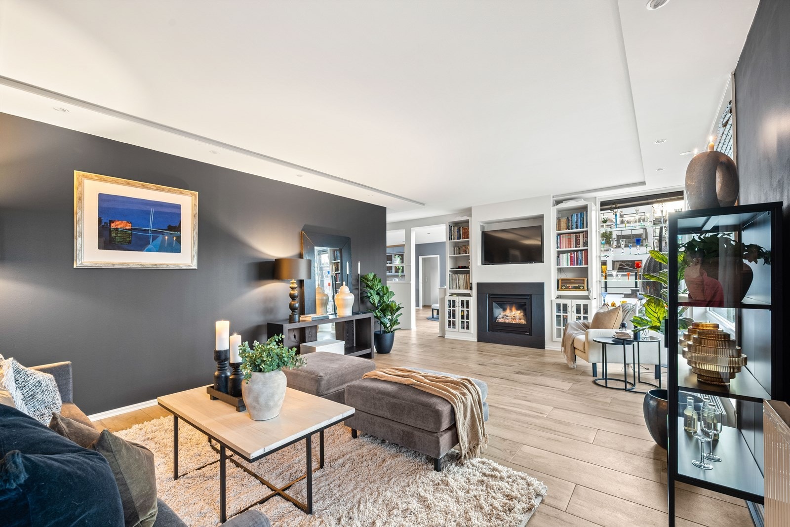 Stor stue med i innfelte lys i himling, et gulv som kombinerer det beste fra to verdener: den robuste holdbarheten til fliser og den varme, naturlige estetikken til parkett. Flisene har en tekstur og fargetone som gir inntrykk av ekte treverk. Galleribilde