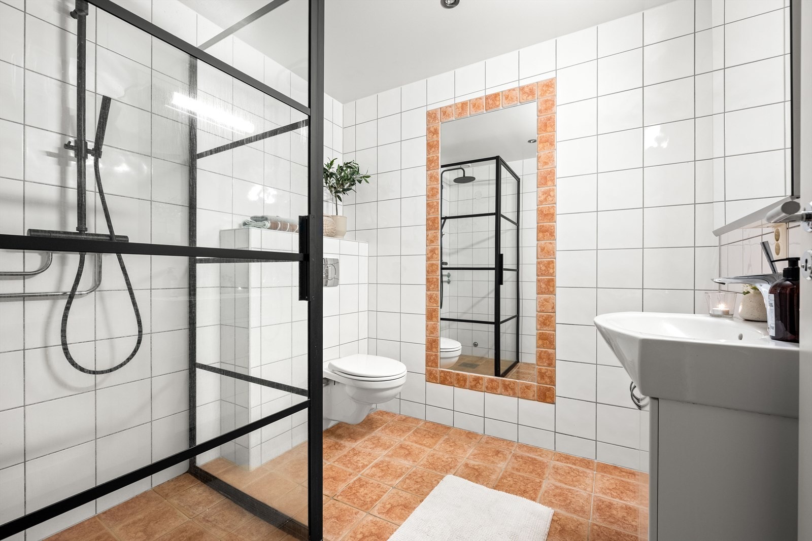 Badet er oppgradert med nytt sort dusjkabinett, stort innfliset speil, vegghengt WC og elektriske håndkletørkere. Her er det også uttak for vaskemaskin og tørketrommel, samt varmekabler i gulvet. Galleribilde