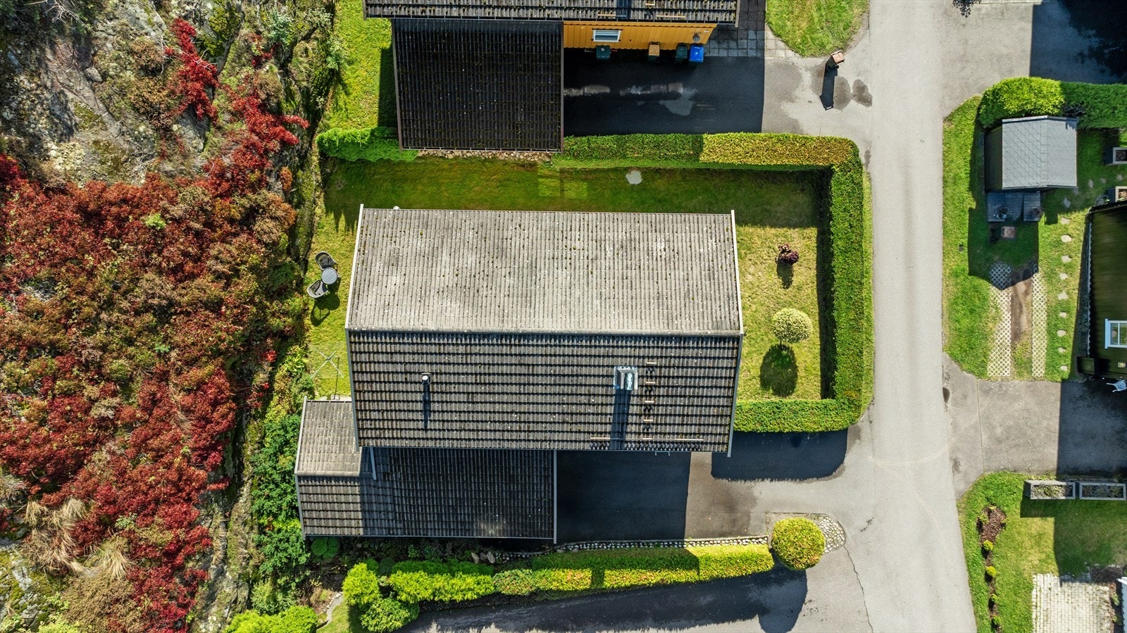 Boligens tomt er pent rammet inn av velholdt vintergrønn hekk Galleribilde