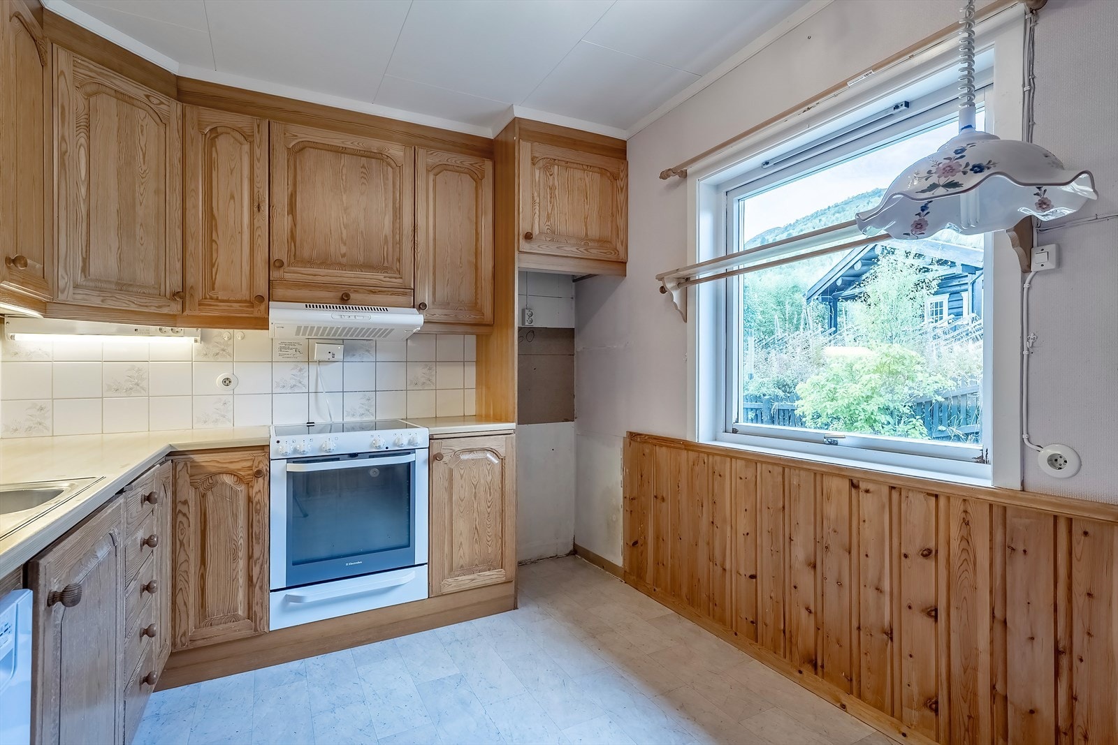 Kjøkkenet har innredning med fronter i profilert furu fra slutten av 80-tallet Galleribilde