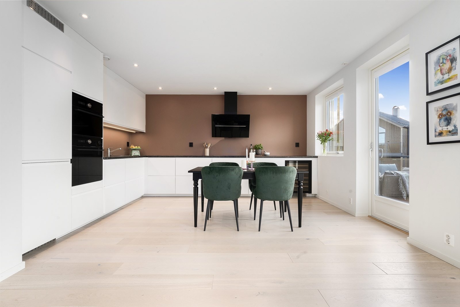 Moderne og tidsriktig kjøkkeninnredning med hvite slette fronter, benkeplate av stein. Galleribilde