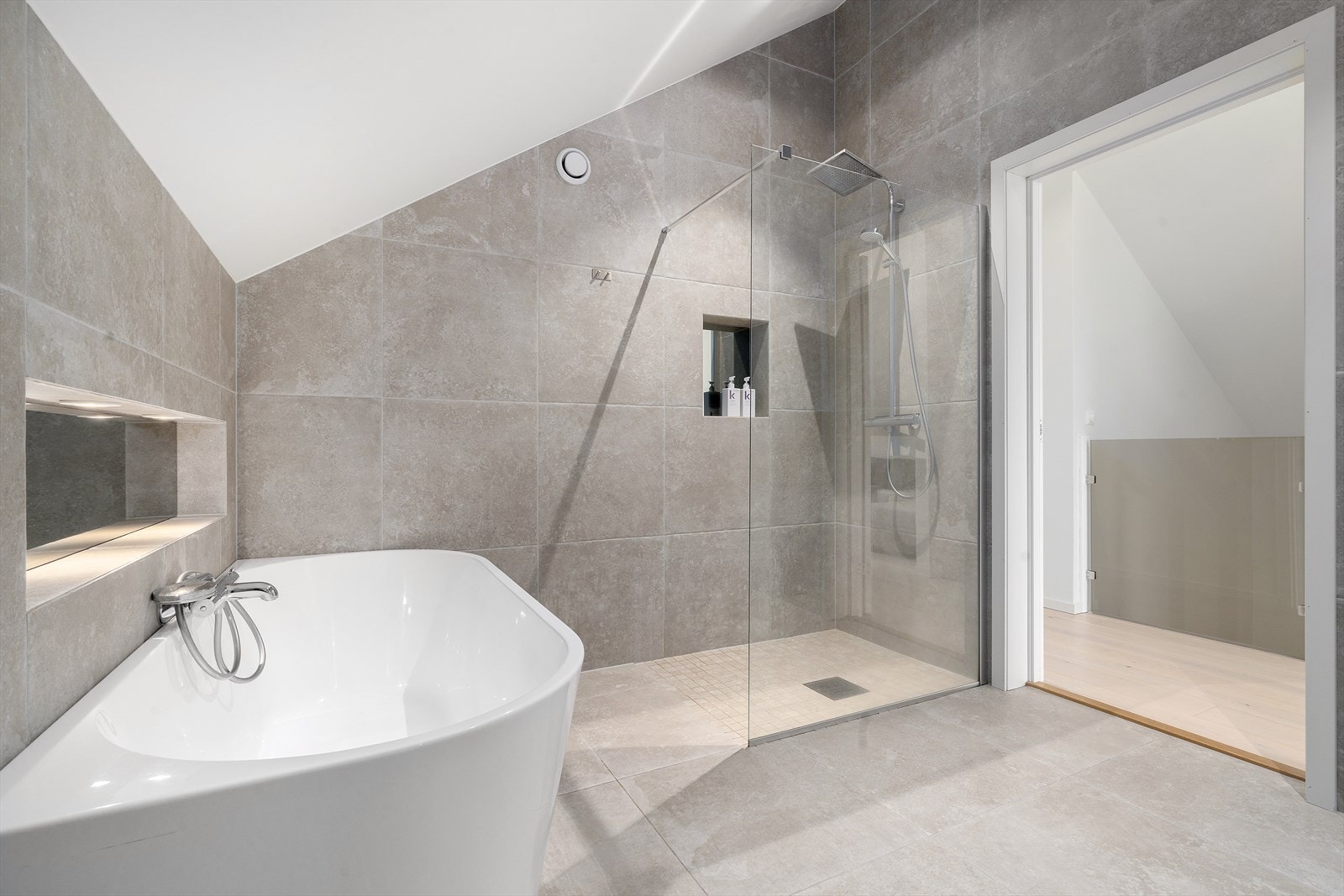 Badet ligger praktisk til i tilknytning til soverommene i 3.etasje. Praktiske innebygde nisjer i vegg både i dusjsone og ved badekar, perfekt for såper og dusjprodukter. Galleribilde