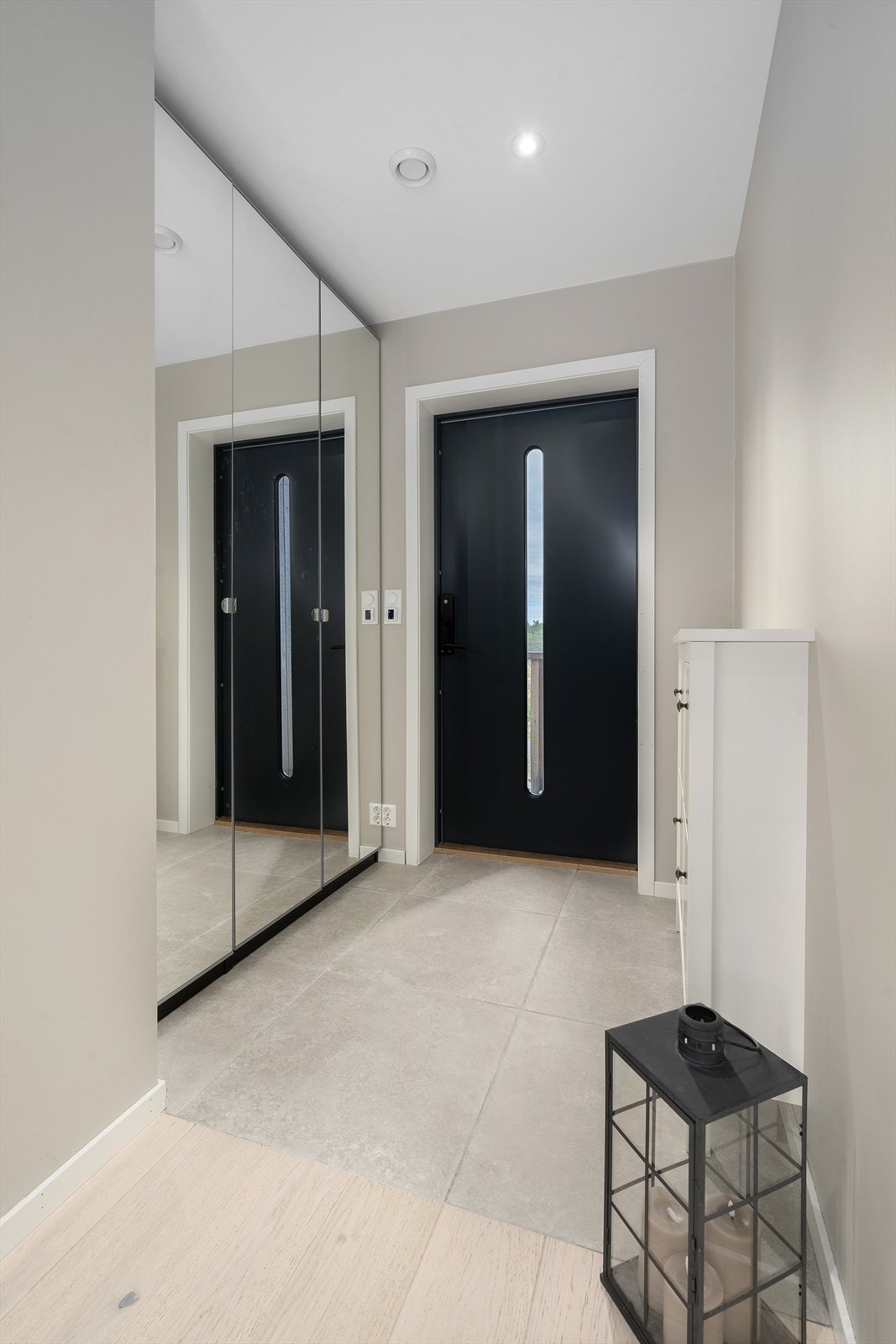 Lys og romslig flislagt entré med varmekabler. Det er gode oppbevaringsmuligheter i en praktisk skyvedørsgarderobe i nisje, for yttertøy og til å sette ifra seg sko, noe som gjør det enkelt å holde orden i inngangspartiet Galleribilde