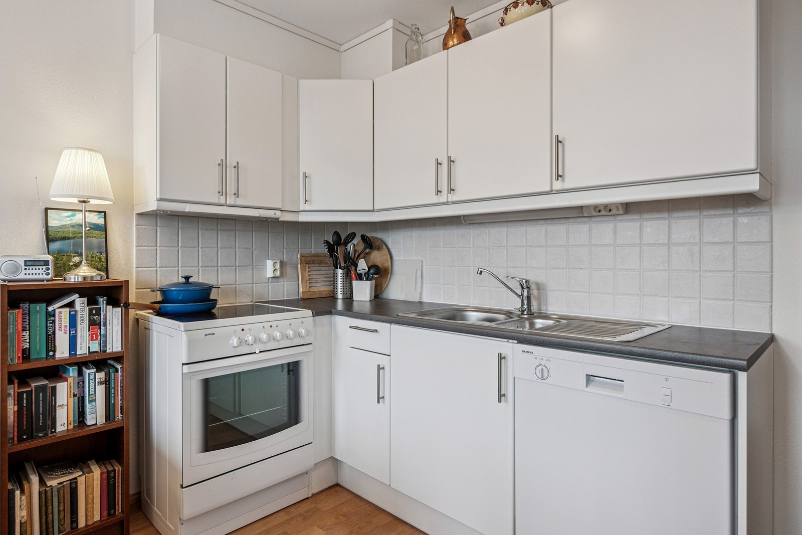 Kjøkkeninnredning med over-og underskap, og oppvaskkum nedfelt i laminat benkeplate. Galleribilde