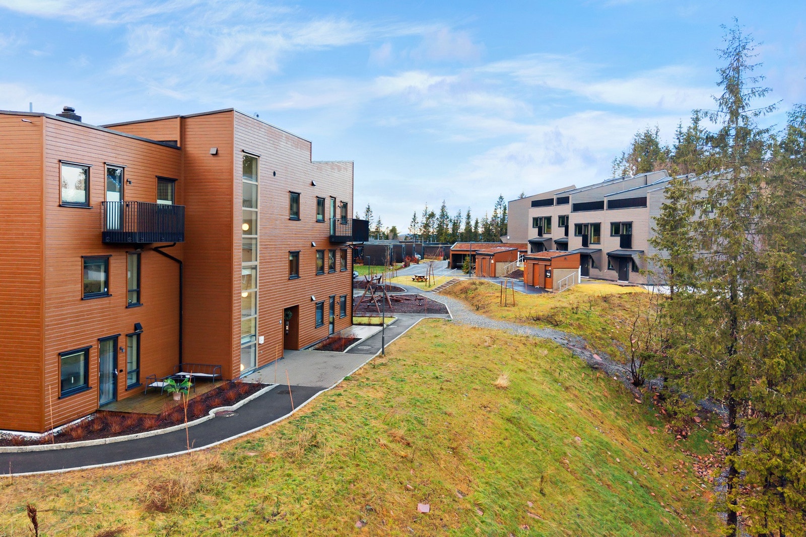 Luftige uteområder omkranser bygningene i Vitigrend boligsameie. Galleribilde