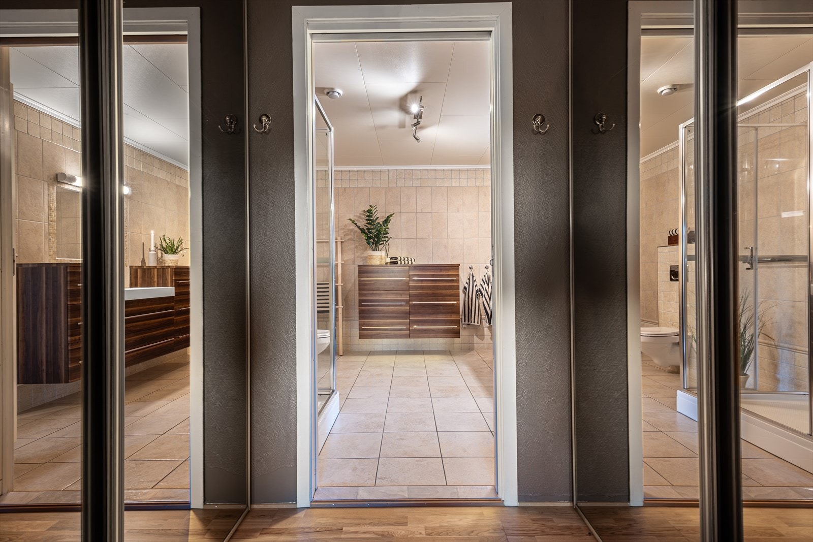 Løsningen er særlig praktisk ved at badet er plassert på motsatt side av hovedsoverommet og garderoberommet, noe som gir en funksjonell og privat planløsning. Galleribilde