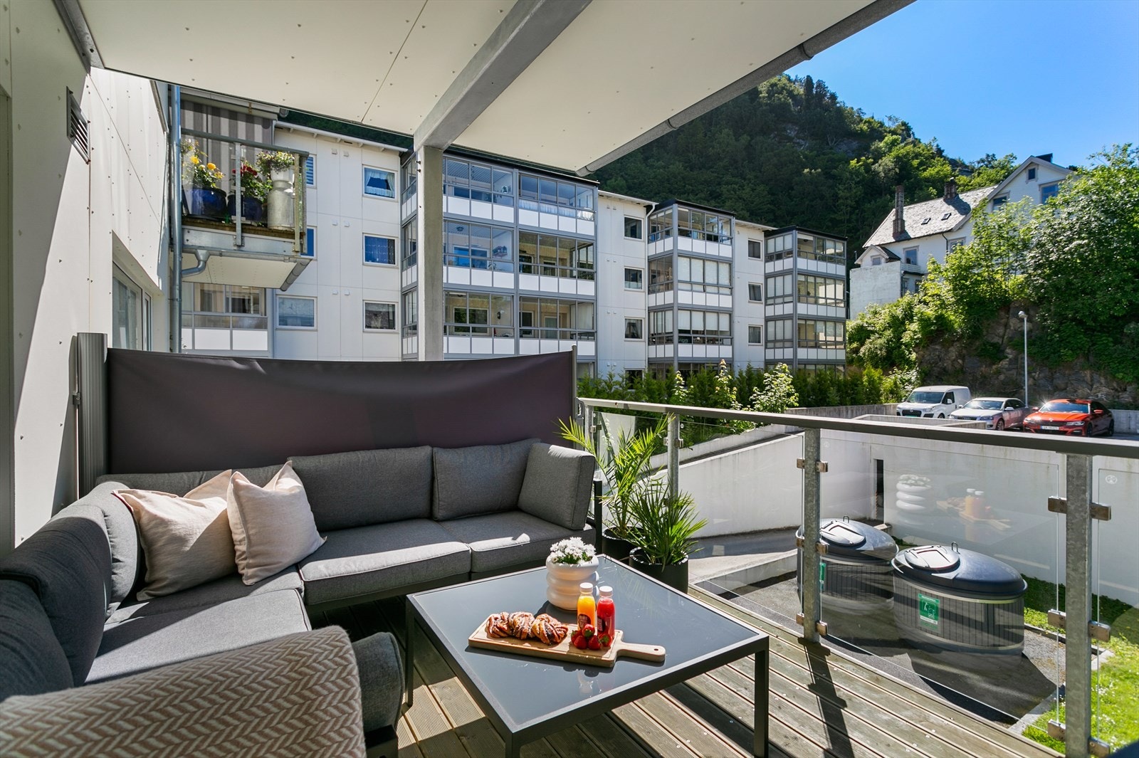 Balkongen har et areal på 10 m² og er utstyrt med glassrekkverk og royalimpregnert terrassebord, som gir en solid og stilfull utforming Galleribilde