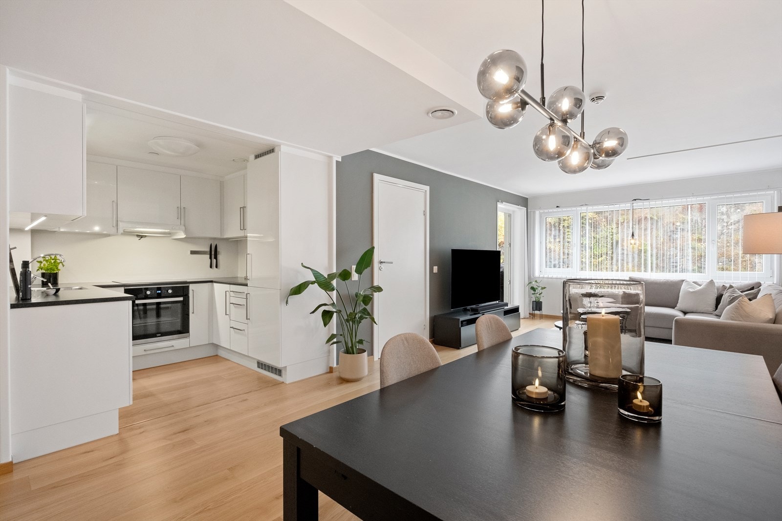 Åpen kjøkkenløsning med glatte fronter og laminat benkeplate gir et moderne uttrykk Galleribilde