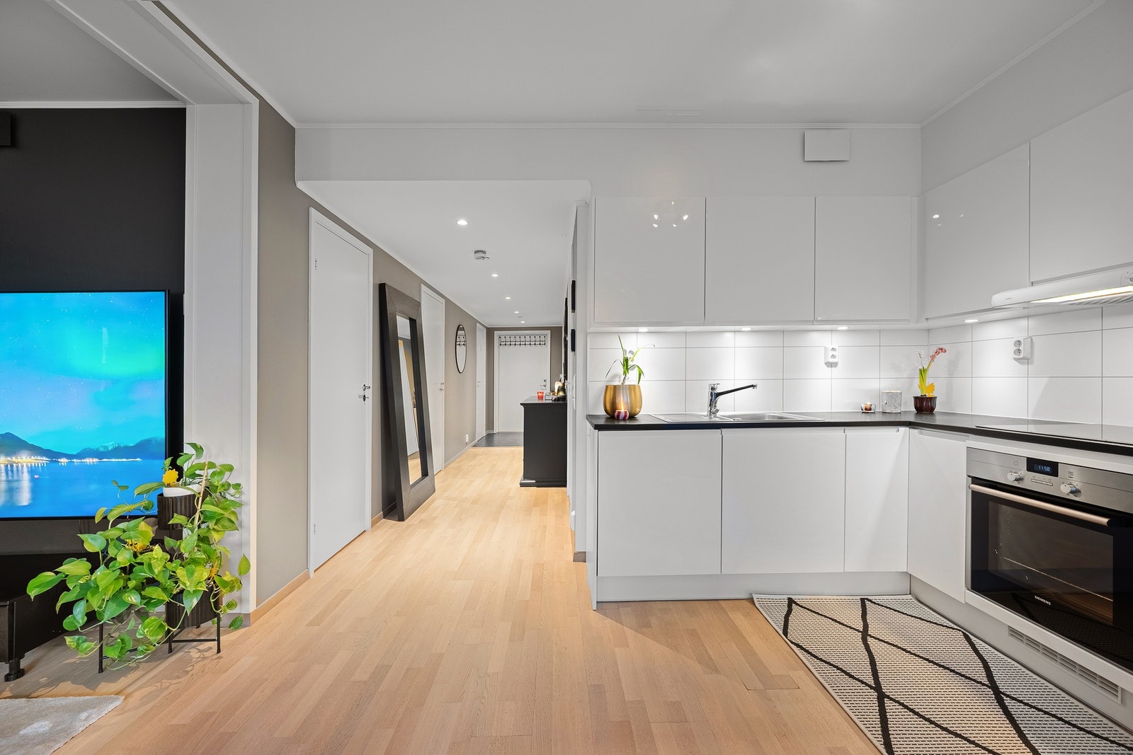 Videre inn i stue og kjøkken ligger det parkett som skaper en varm og helhetlig atmosfære. Galleribilde