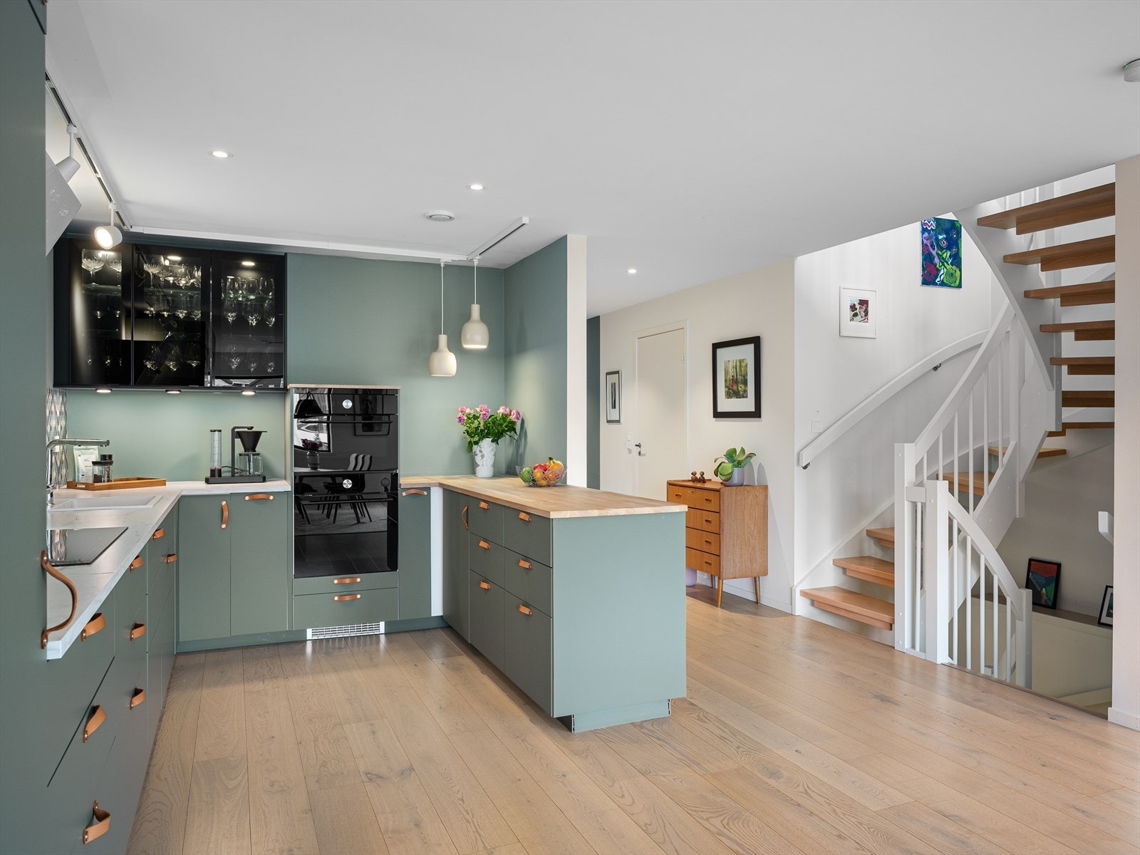 Hovedstue og kjøkken i åpen løsning med mye naturlig lys og en herlig romfølelse. Galleribilde