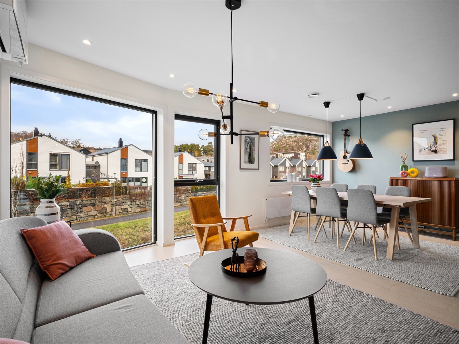 En herlig romfølelse med kombinasjonen av store vinduer og naturlig lys, peisovn for ekstra varme og atmosfære, samt naturlige soner for møblering. Galleribilde