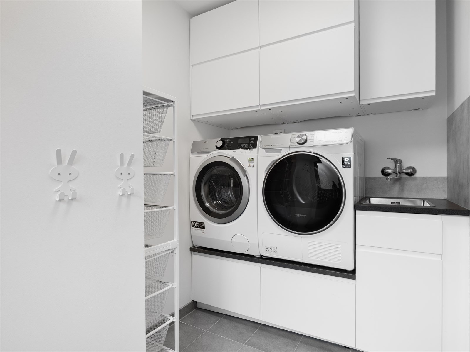 Vaskerom/bi-inngang med svært godt utnyttet skapplass. Maskiner i arbeidshøyde. Galleribilde
