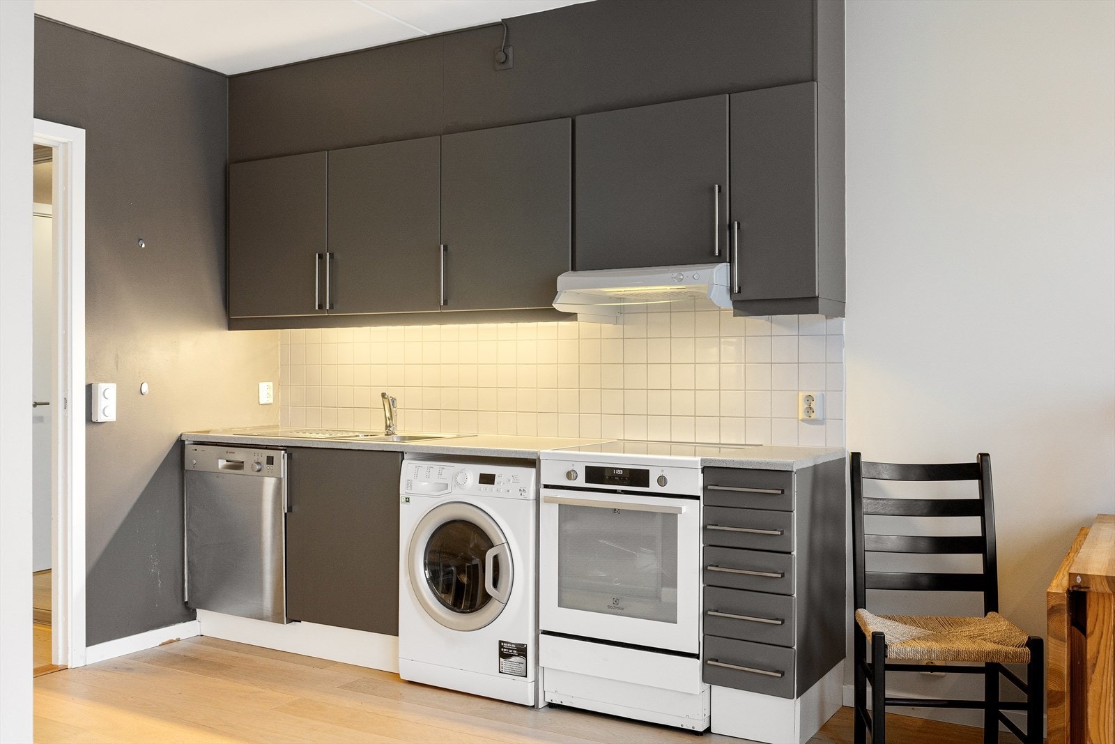 Kjøkkenet fremstår som moderne og funksjonelt, med rikelig skap- og benkeplass. Innredningen har slette fronter og er utstyrt med frittstående hvitevarer. Galleribilde