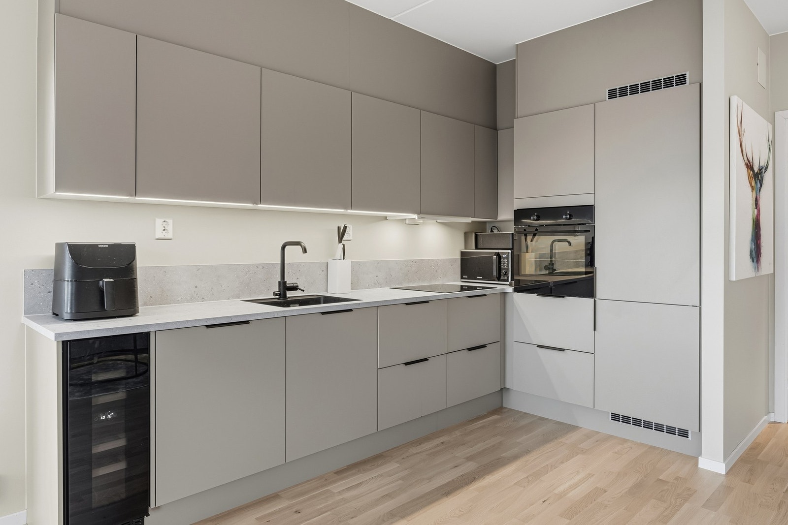 Induksjonstopp, vinskap, stekeovn, oppvaskmaskin og kjøl/frys er integrert i innredningen. Galleribilde