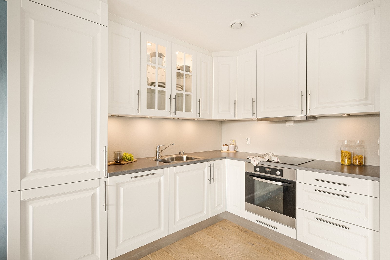 Fint kjøkken med integrerte hvitevarer som komfyr, platetopp, kjøleskap, fryseskap og oppvaskmaskin. Galleribilde