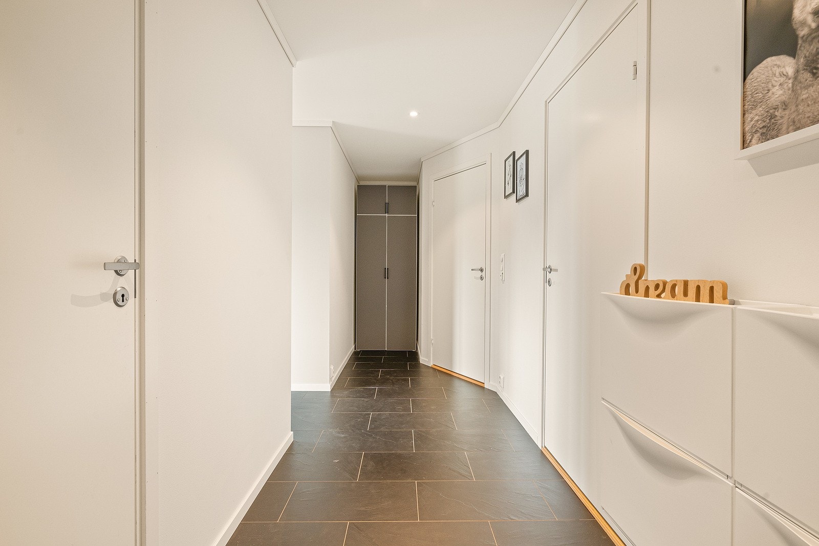 Leiligheten har en romslig gang med varmekabler i gulv. Her er det flislagt gulv og slette vegger. Galleribilde