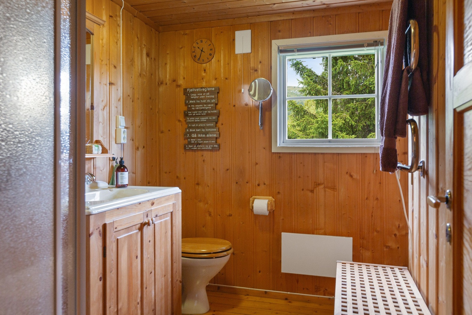 Hyttebad innredet med servantskap, dusjkabinett og toalett. Galleribilde