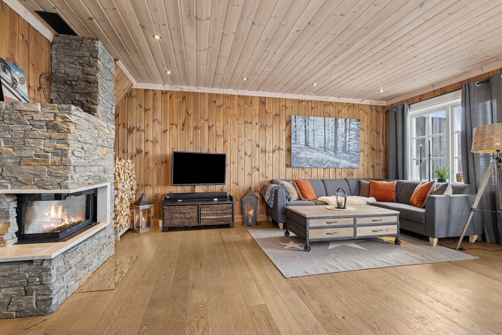 Fra stuen er det utgang til en stor og solrik veranda med plass for både avslapning og sosiale sammenkomster. Hytta holder høy kvalitet, med panelte vegger, gode spotløsninger, skiferbelagt peis og gulv i eik. Galleribilde