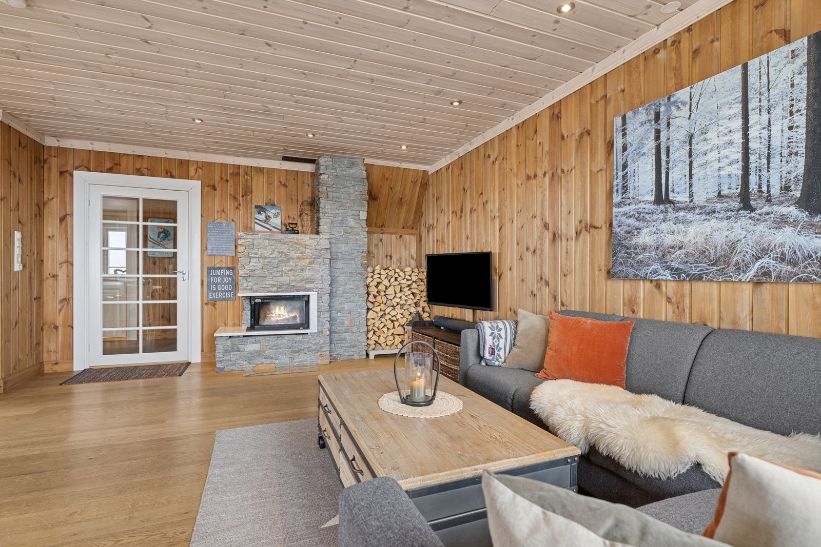 Stor og romslig stue med møbleringsvennlig planløsning og to soner - kjøkken med spiseplass og en hyggelig sofakrok. Her kan du nyte en herlig peis, flott utsikt og avslapning når det ikke er TV-tid. Galleribilde