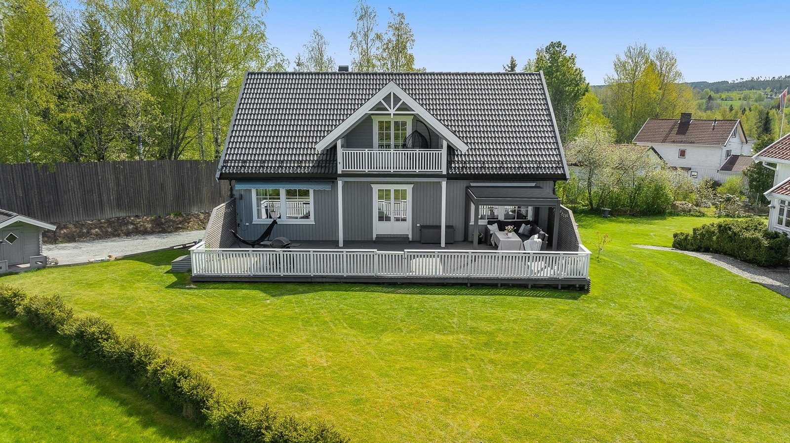 Eiendommen har en pent opparbeidet tomt med beplantning mot nabo og grøntarealer. Galleribilde