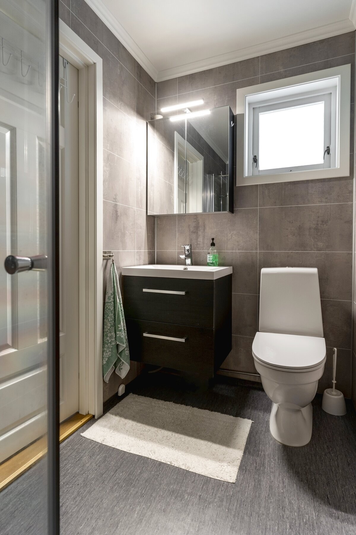 Badet er innredet med servantskap med skuffer, dusjvegger og toalett. Galleribilde