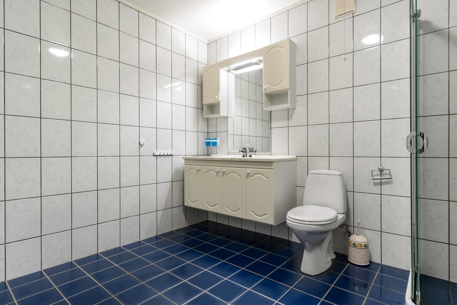 Flislagt bad av god størrelse innredet med baderomsinnredning, dusjvegger og toalett. Galleribilde