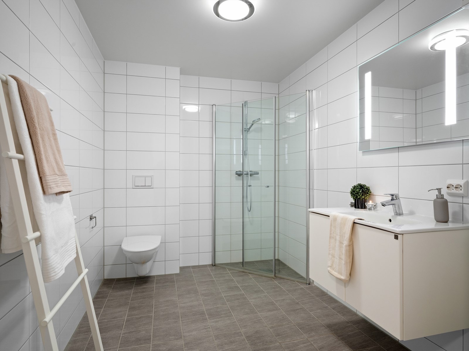 Lyst og moderne bad med stilrent design, romslig dusjhjørne og praktisk oppbevaring. Varme i gulv. Galleribilde