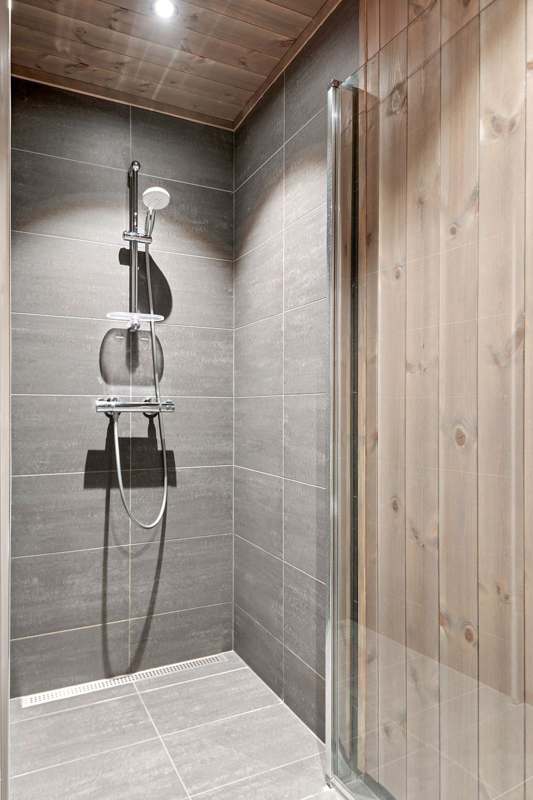 Flislagt dusjnisje med klassisk og tidløse flisvalg med dusjdør i herdet glass. Galleribilde