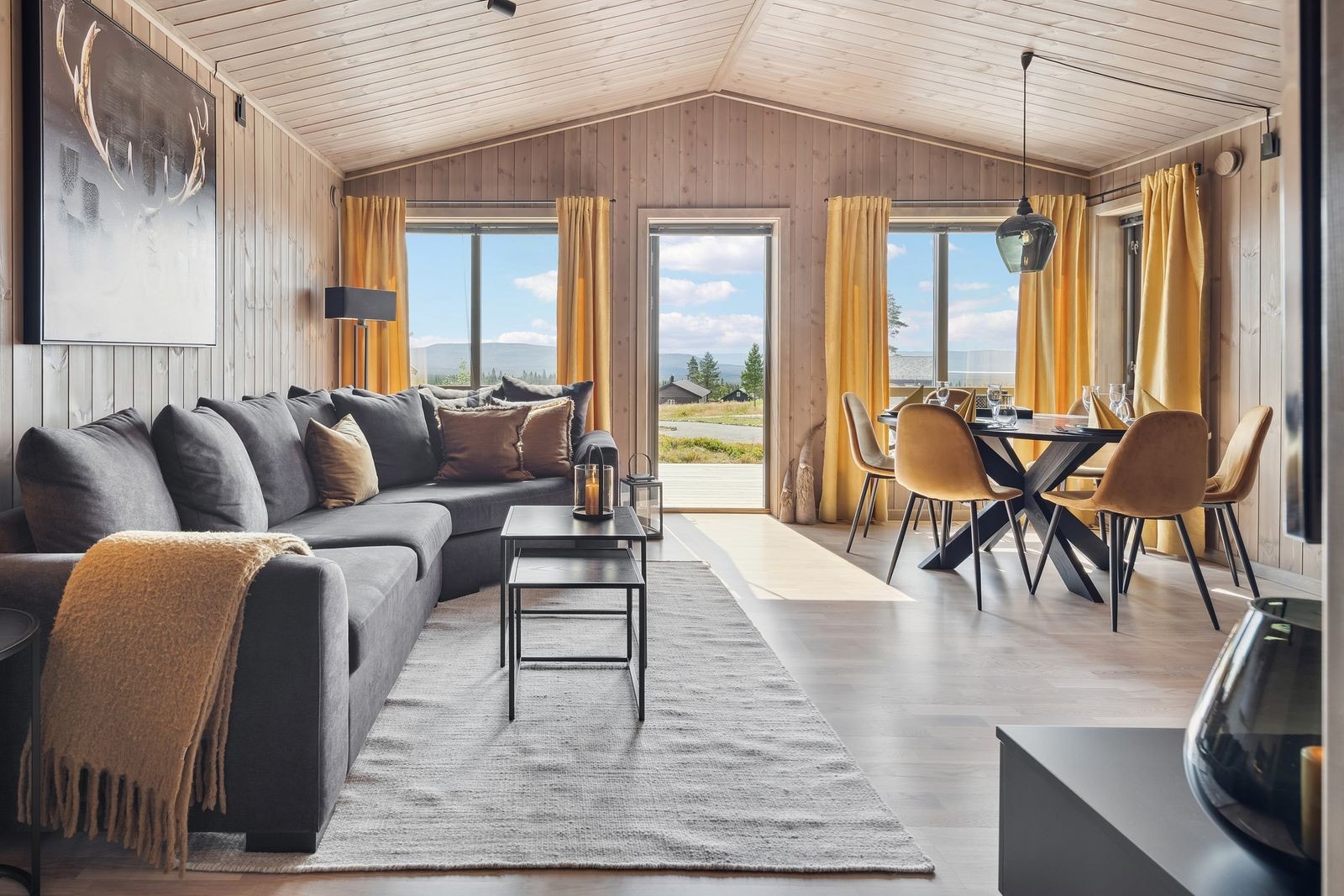 Når du trår inn i hytta, møtes du av en åpen og innbydende stue- og kjøkkenløsning som umiddelbart skaper en romslig og sosial atmosfære. De store vindusflatene slipper inn rikelig med naturlig lys og gir en herlig følelse av nærhet til naturen utenfor. Galleribilde