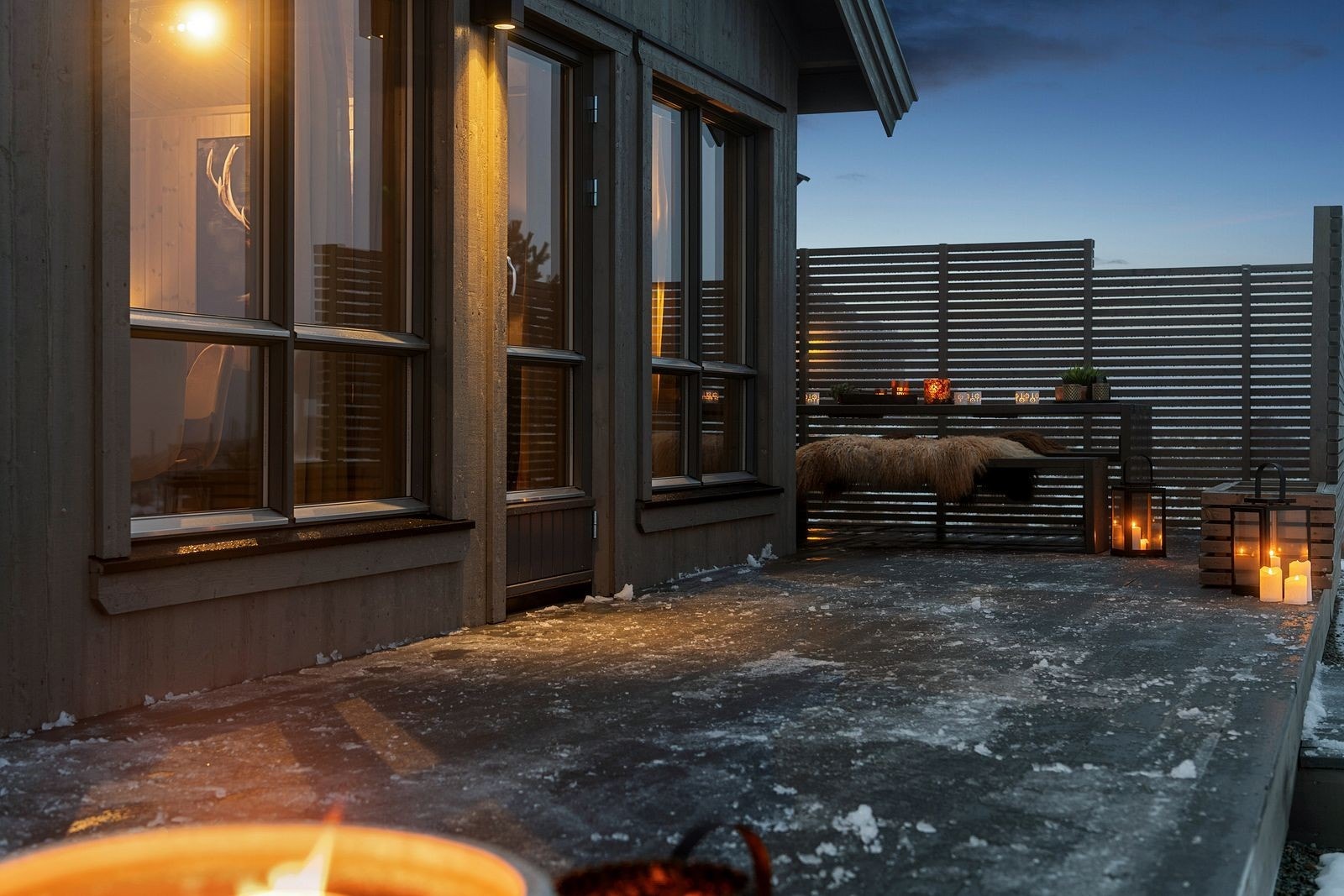 Hytta byr på en generøs terrasse som rammer inn uteområdet og gir rikelig med plass til både avslapning og sosiale stunder. De stilrene spileveggene skaper en lun og skjermet atmosfære, slik at du kan nyte fjellufta uansett vær. Galleribilde