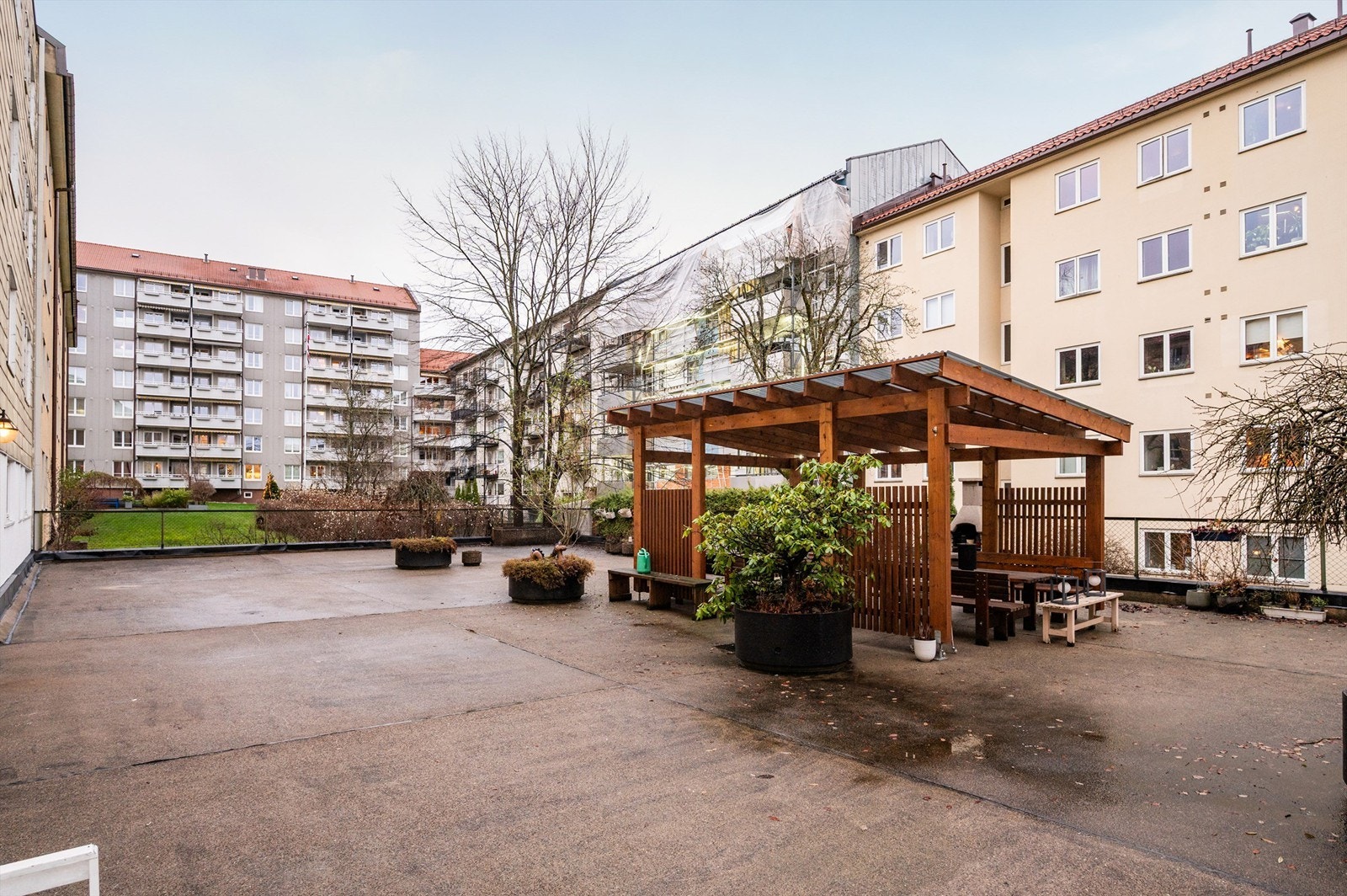 Trivelig bakgård med opparbeidete sitteplasser og beplantning. Galleribilde