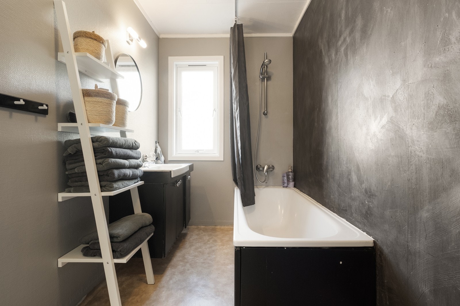 Badet har våtromsbelegg med varmekabler på gulv og respatex-plater på vegger. Utstyrt med badekar m/ dusj og servant med underskap. Galleribilde