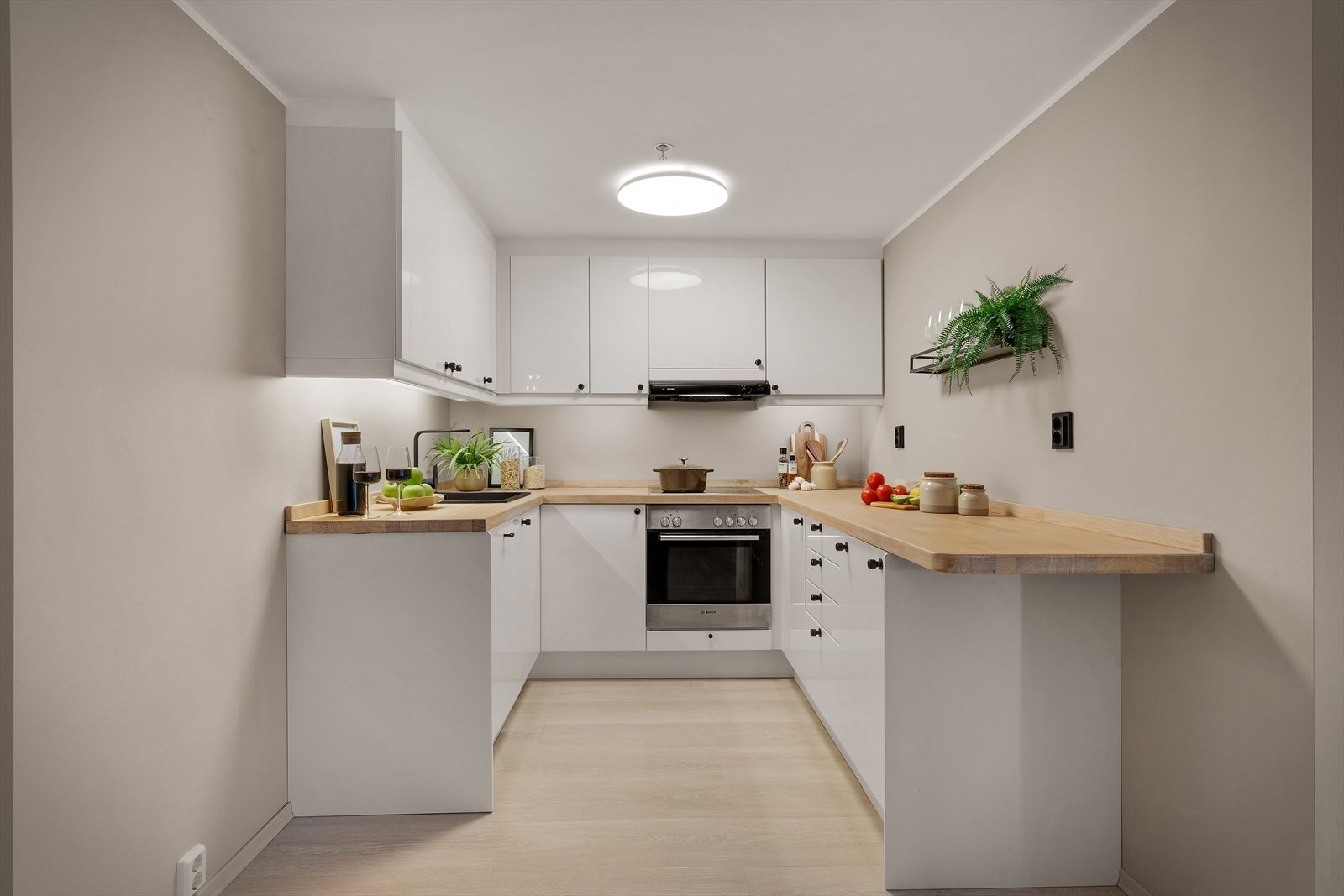 - Kjøkkenet er innredet med hvite høyglansfronter, vask i kompositt og heltre-benkeplate - Galleribilde