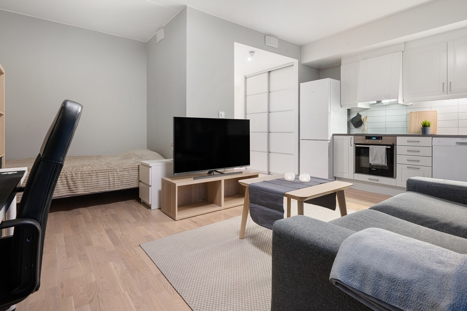 Åpen stue- og kjøkkenløsning med parkettgulv og godt med naturlig lys fra store vinduer. Galleribilde