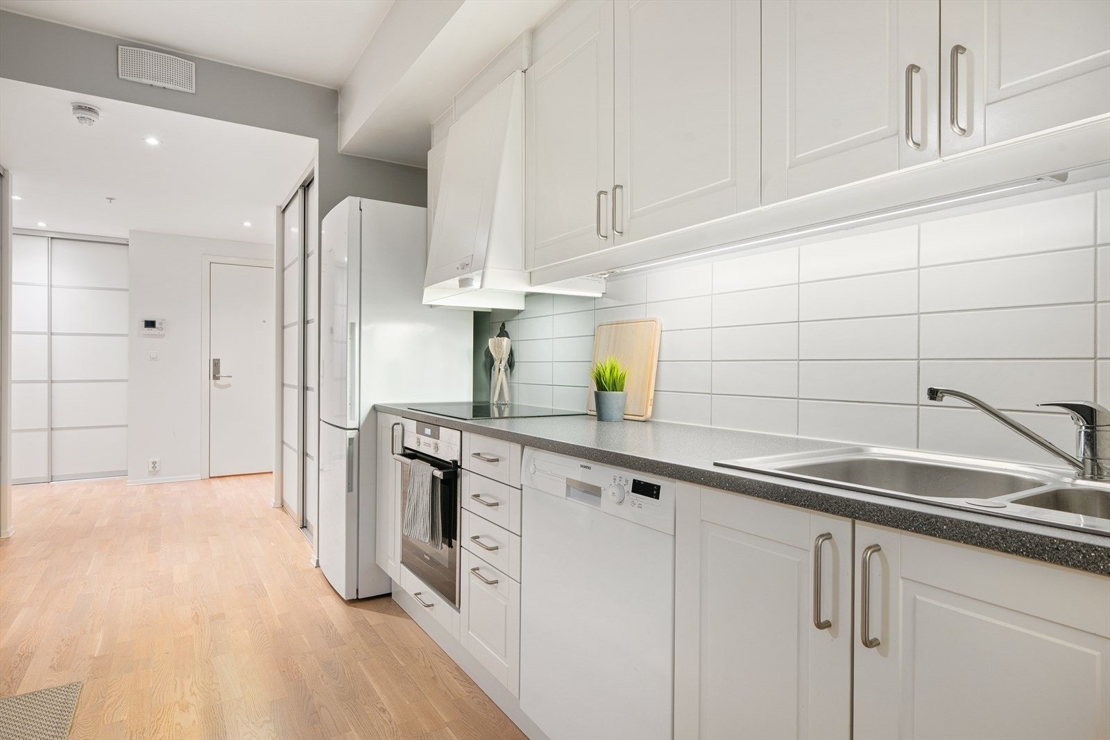 Kjøkkenet har profilerte fronter og laminat benkeplate, samt integrert komfyr og frittstående oppvaskmaskin. Galleribilde