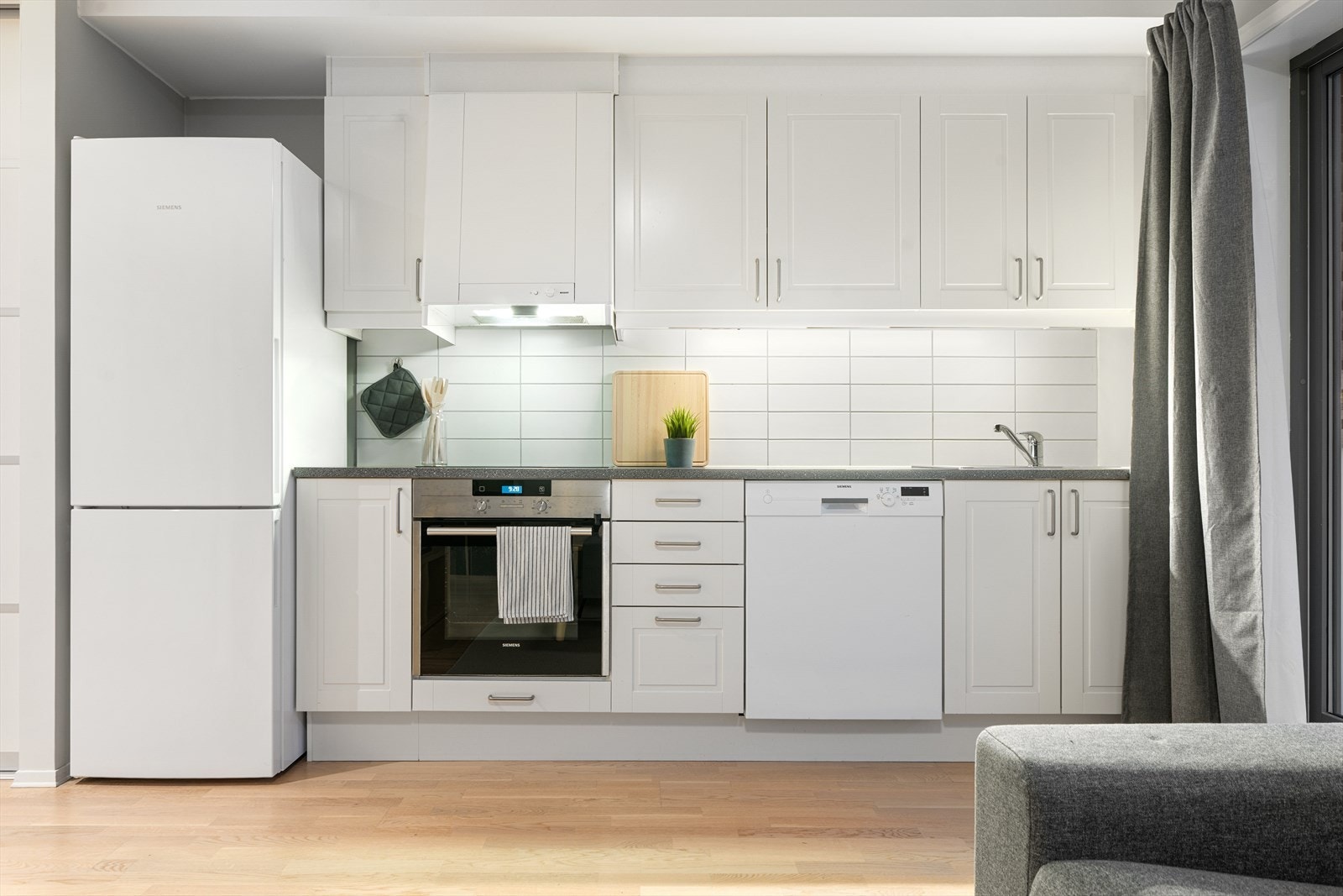 Kjøkkenet er utstyrt med hvite profilerte fronter og en overlimt oppvaskkum, samt mekanisk avtrekk over platetopp. Galleribilde