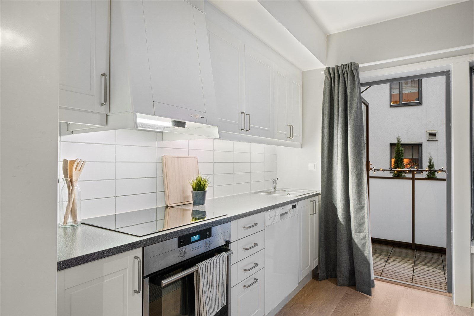 Kjøkkenet har hvite profilerte fronter og mekanisk avtrekk. Galleribilde