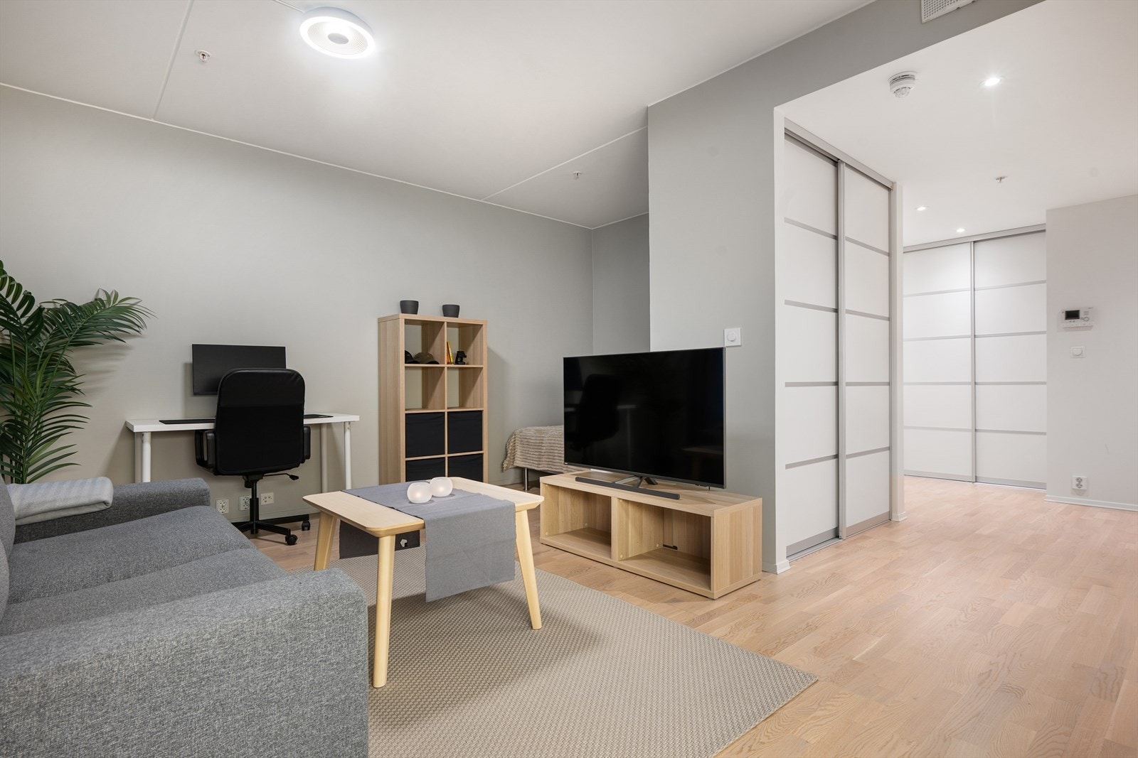 Stuen har parkettgulv og slette malte vegger, med en praktisk kontorplass i hjørnet. Galleribilde